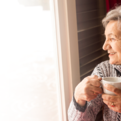 Senior woman holding a mug while looking out a window
