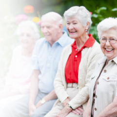 Four smiling seniors enjoying outdoor spring activities at an assisted living community