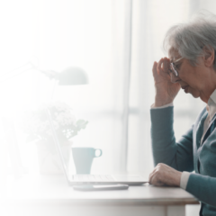 Senior woman sitting in front of a computer seeming confused, representing memory changes